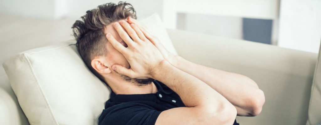 Stressed man holding his head due to headache